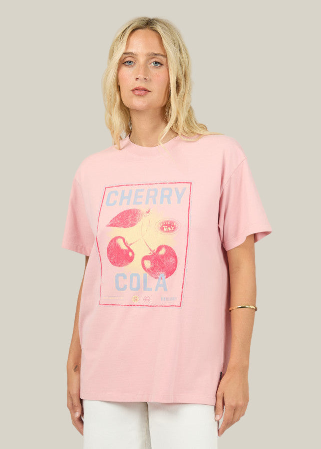Woman wearing a pink t-shirt with cherry cola graphic design on a plain background